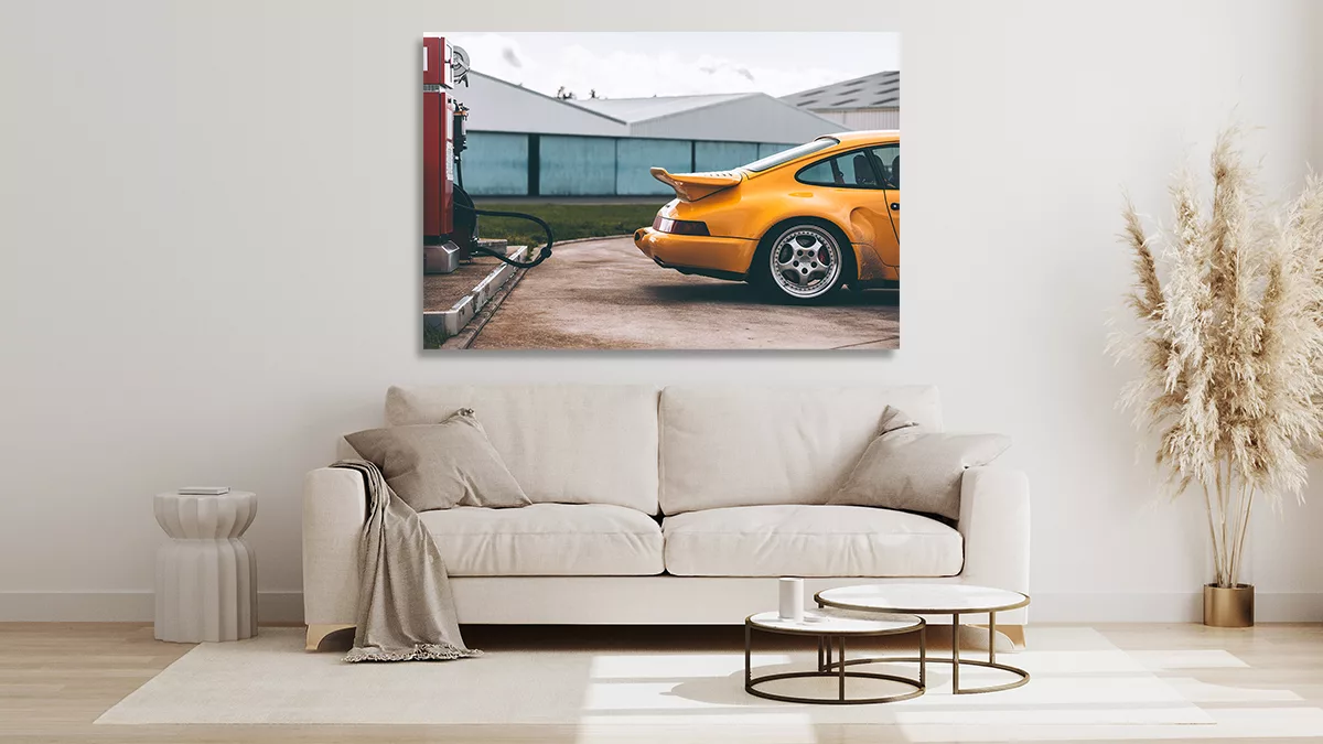 Tirage fine art Porsche 930 Turbo S jaune exposé en toile dans un salon moderne lumineux avec canapé beige et décoration pampa, mockup mural Cars and Roses