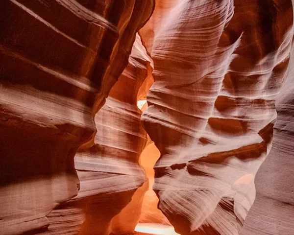 Photographie Antelope Canyon - Upper Side Photographie artistique de l'Upper Antelope Canyon en Arizona montrant les parois de grès sculptées par l'érosion avec des rayons de lumière filtrant à travers les fissures, créant des nuances orange et rouges, tirage d'art limité
