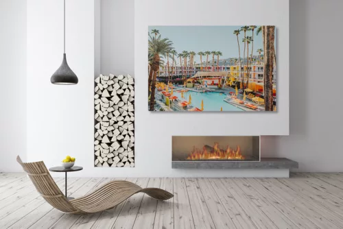 Photo The Saguaro Palm Springs Photographie artistique de l'hôtel The Saguaro à Palm Springs avec sa façade multicolore, sa piscine turquoise, ses parasols jaunes et ses palmiers sous le ciel bleu californien