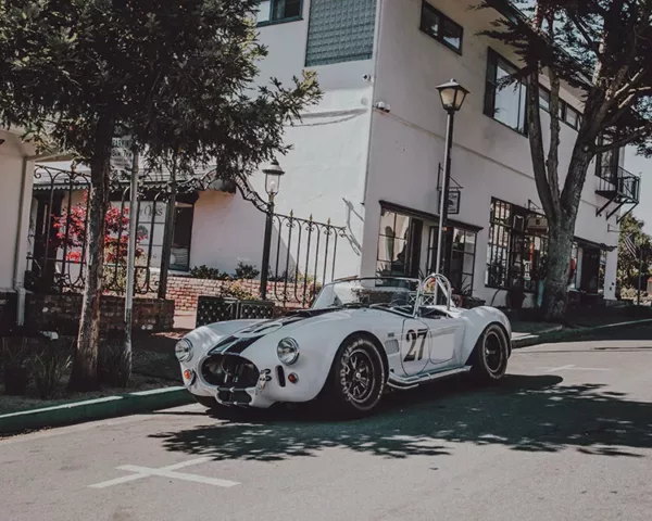 Photographie de voiture américaine Photographie artistique d'une Shelby Cobra 427 blanche avec bandes de course noires numéro 27 dans les rues pittoresques de Carmel-by-the-Sea, Californie