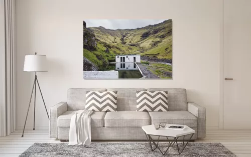 Photographie d'art de la piscine géothermique Seljavallalaug en Islande, eau turquoise entourée de montagnes volcaniques, paysage nordique sauvage