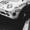 Photo Ford GT40 NB Photographie noir et blanc de l'arrière d'une Ford GT40 de course numéro 6 avec sponsors Ferodo et Koni, sur piste mouillée