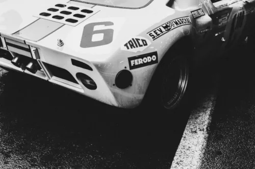 Photo Ford GT40 NB Photographie noir et blanc de l'arrière d'une Ford GT40 de course numéro 6 avec sponsors Ferodo et Koni, sur piste mouillée