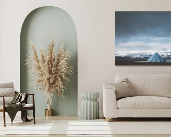 Photographie du Svalbard montrant une tente tipi bleue solitaire face aux montagnes enneigées des fjords arctiques sous un ciel dramatique