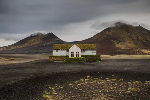 Restaurant solitaire couvert de mousse dans les hautes terres volcaniques du nord-est de l'Islande près de Möðrudalsleið avec montagnes dramatiques