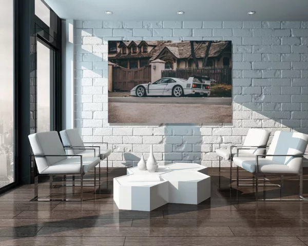 Tirage d'art Ferrari F40 grise affiché sur grande toile dans salon moderne minimaliste avec mur de briques blanches, mobilier contemporain et lumière naturelle