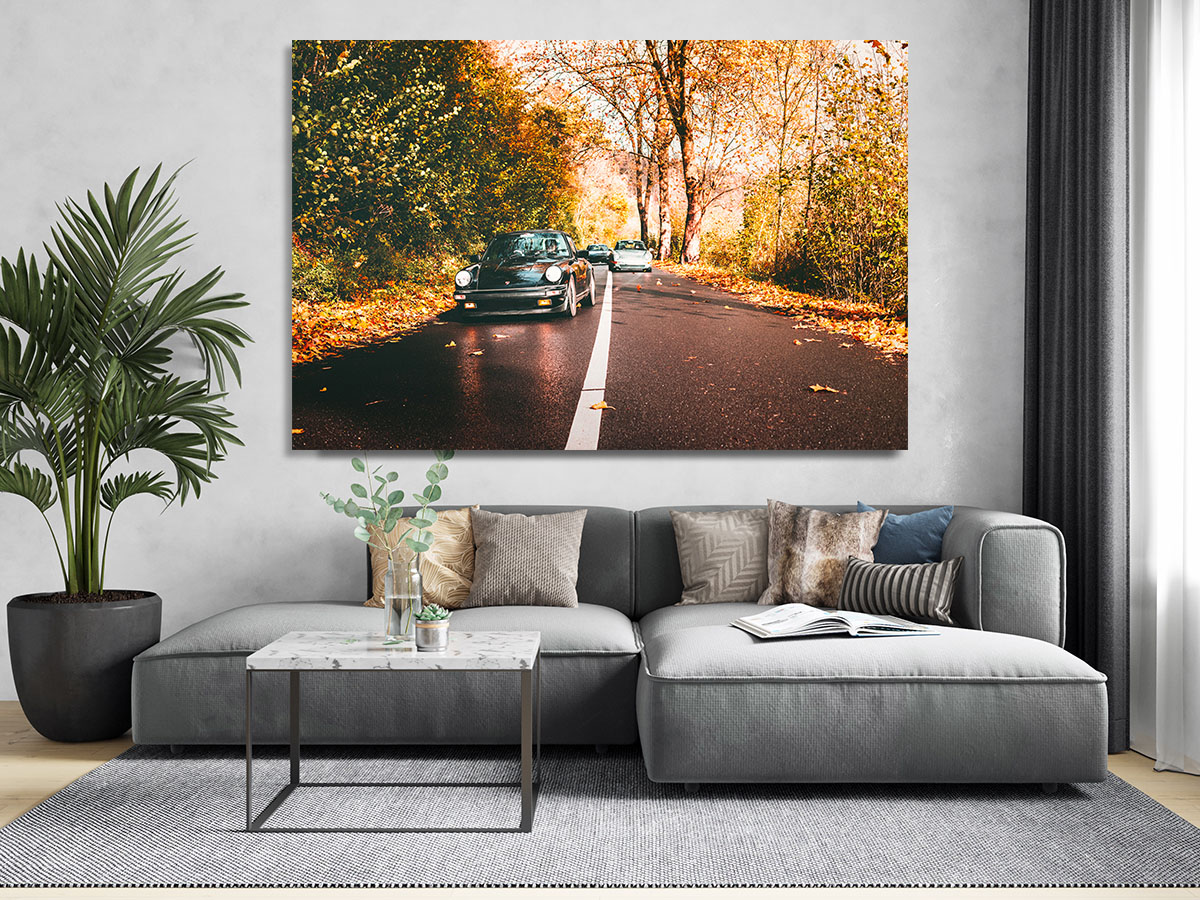 Vue d’une voiture de sport ancienne sur une route boisée en automne, paysage coloré et feuilles tombées. Vue d’une voiture de sport ancienne sur une route boisée en automne, paysage coloré et feuilles tombées.