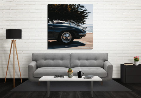 Voiture ancienne photographiée en extérieure, mise en valeur près d’un mur blanc, plan rapproché sur la roue chromée et le cuir bleu, décor moderne intérieur.