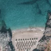 Capture d’écran 2026-06-11 à 23.59.31 Photographie aérienne drone crique secrète Platanias Crète – eaux turquoise cristallines et parasols de plage vus du ciel