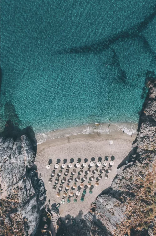 Capture d’écran 2026-06-11 à 23.59.31 Photographie aérienne drone crique secrète Platanias Crète – eaux turquoise cristallines et parasols de plage vus du ciel