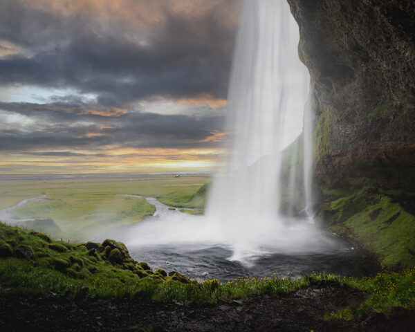 Cascade près d’un littoral verdoyant au soleil couchant, paysage islandais majestueux pour photographie paysages islande conseils