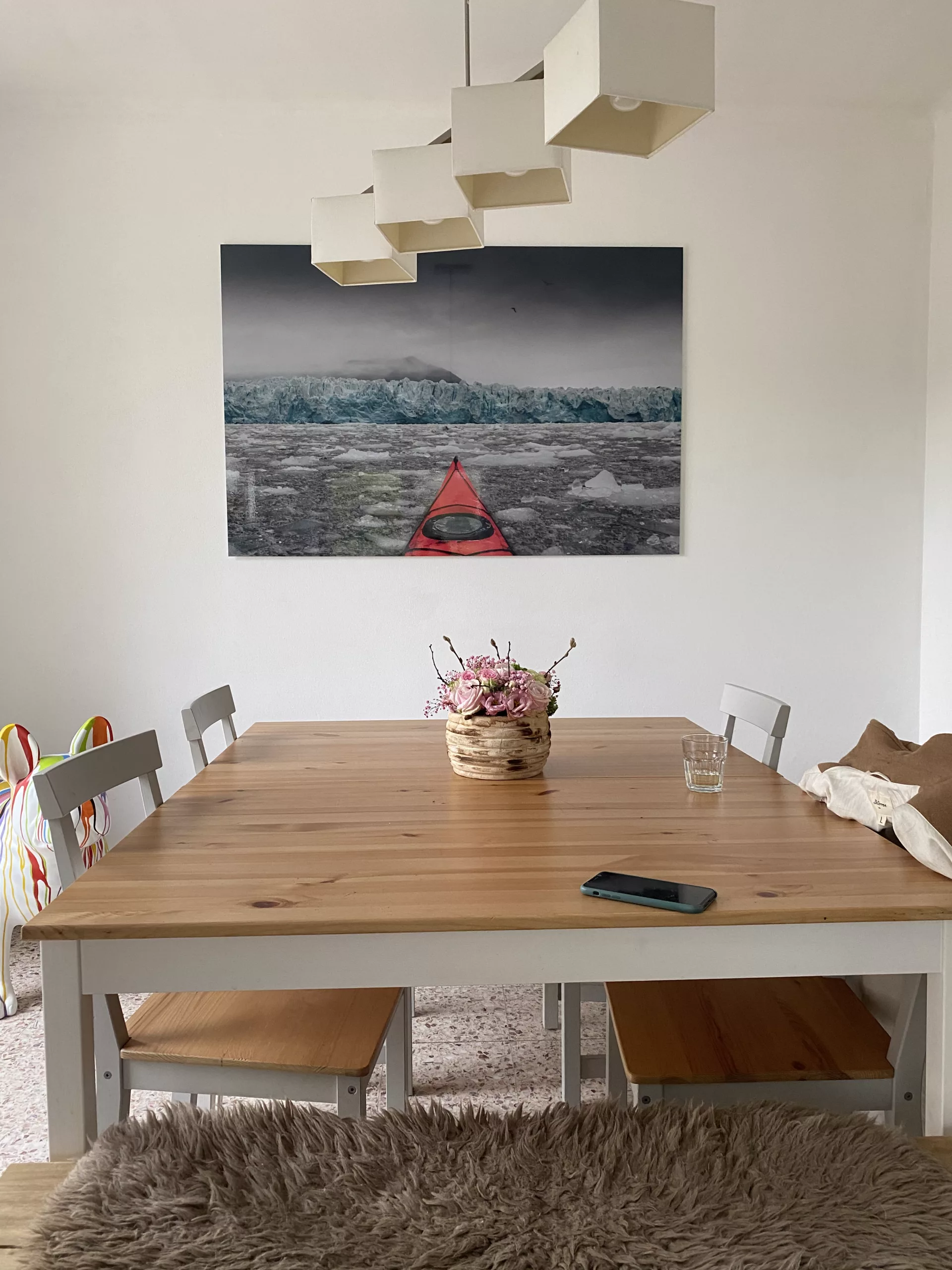 Tirage photographique installé au-dessus d'une table à manger en bois, chaises noires — Cars and Roses