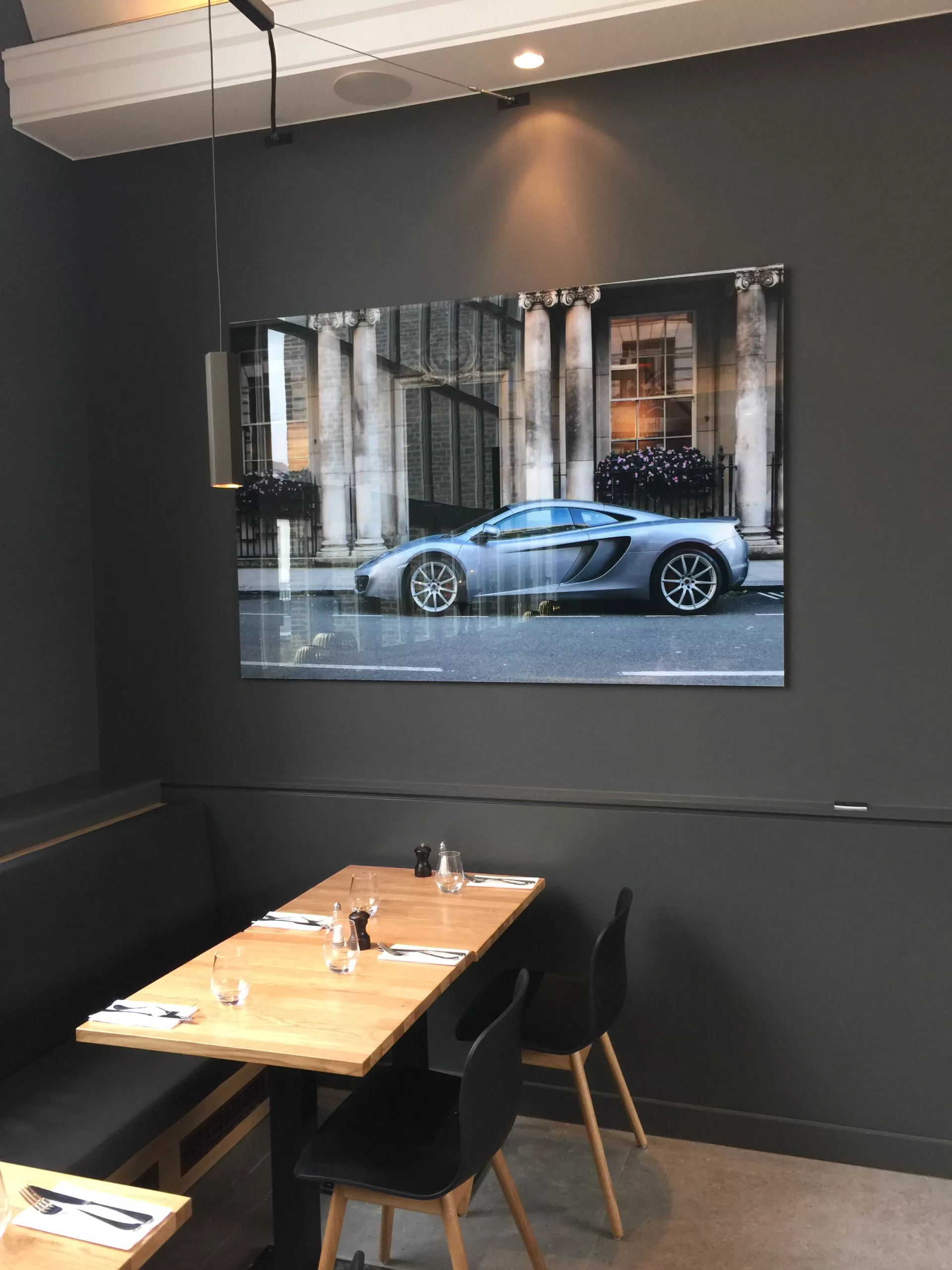 Showroom automobile avec voiture de sport bleue et tirage photographique encadré sur mur sombre — Cars and Roses