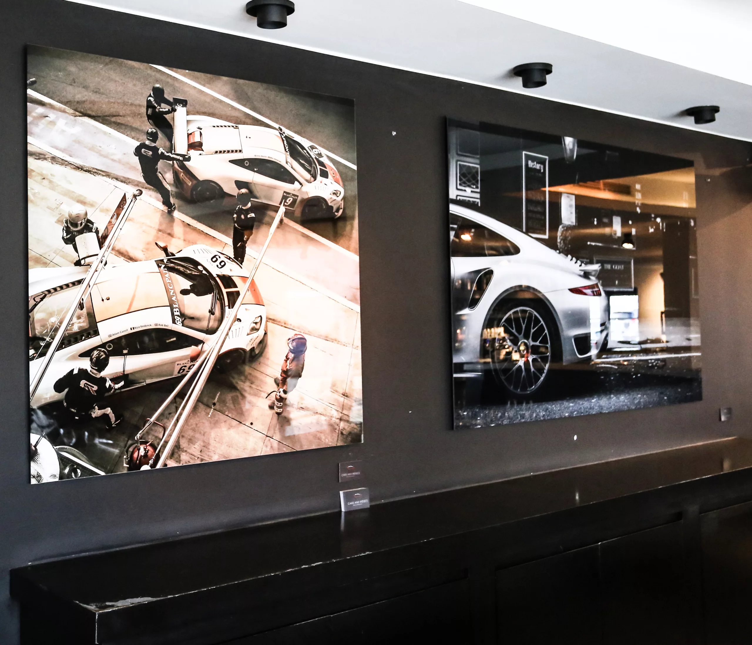 Showroom automobile avec tirage photographique de sport encadré, mur accent rouge — Cars and Roses