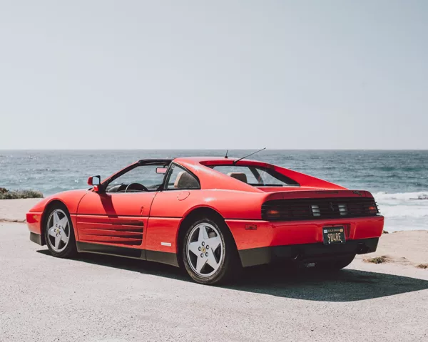 Ferrari 348 TS à Pebble Beach, 17-Mile Drive Ferrari 348 TS rouge garée face à l’océan sur la 17-Mile Drive à Pebble Beach, Californie, vue arrière trois quarts