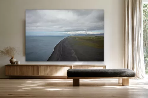 Tableau photographie de la plage de sable noir en Islande accroché au-dessus d'un buffet en chêne clair dans un salon scandinave