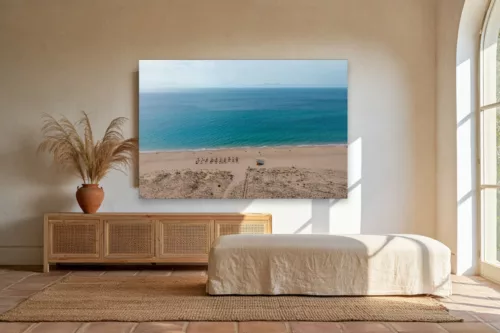 Tableau plage Zahara de los Atunes mockup Tableau photographie de la plage de Zahara de los Atunes en Espagne au-dessus d'un buffet en rotin dans un salon andalou lumineux