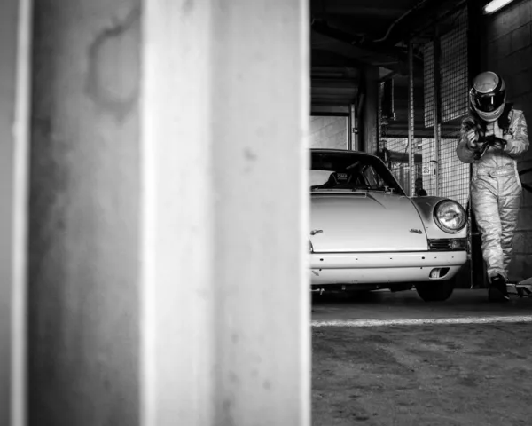 Porsche 911 et son pilote dans le garage des stands — photographie d’art noir et blanc en édition limitée