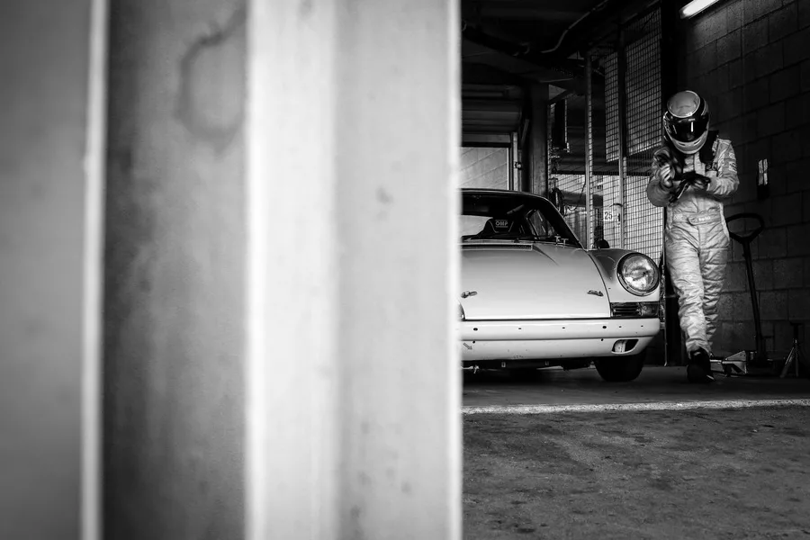 Porsche 911 et son pilote dans le garage des stands — photographie d’art noir et blanc en édition limitée